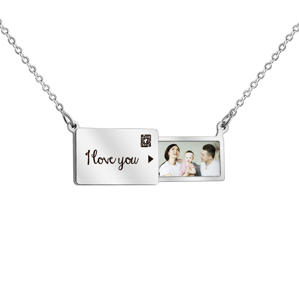 A silver stainless steel pendant necklace with a heart-shaped pull-out box that contains a photo and the text 'I love you'.