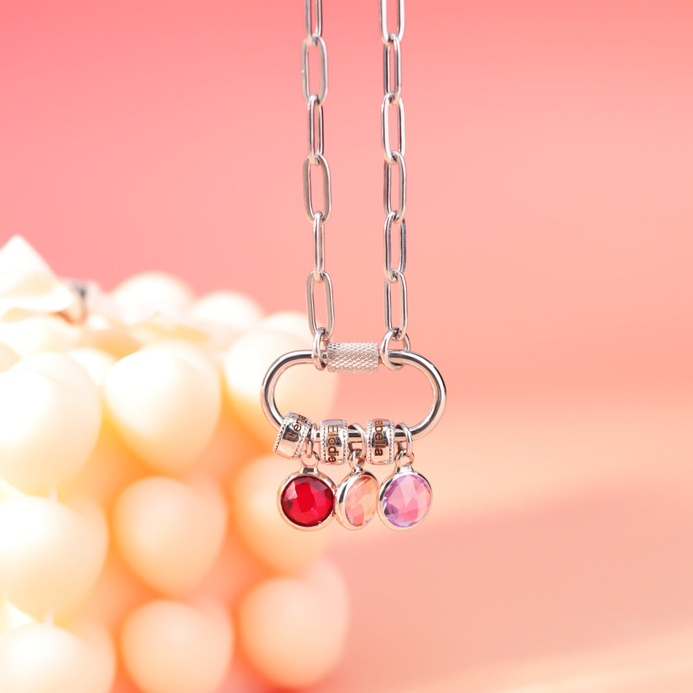 A two-part jewelry set with a pendant and a bracelet, featuring colorful gemstones and metallic clasps, displayed on a surface with pink crystals.