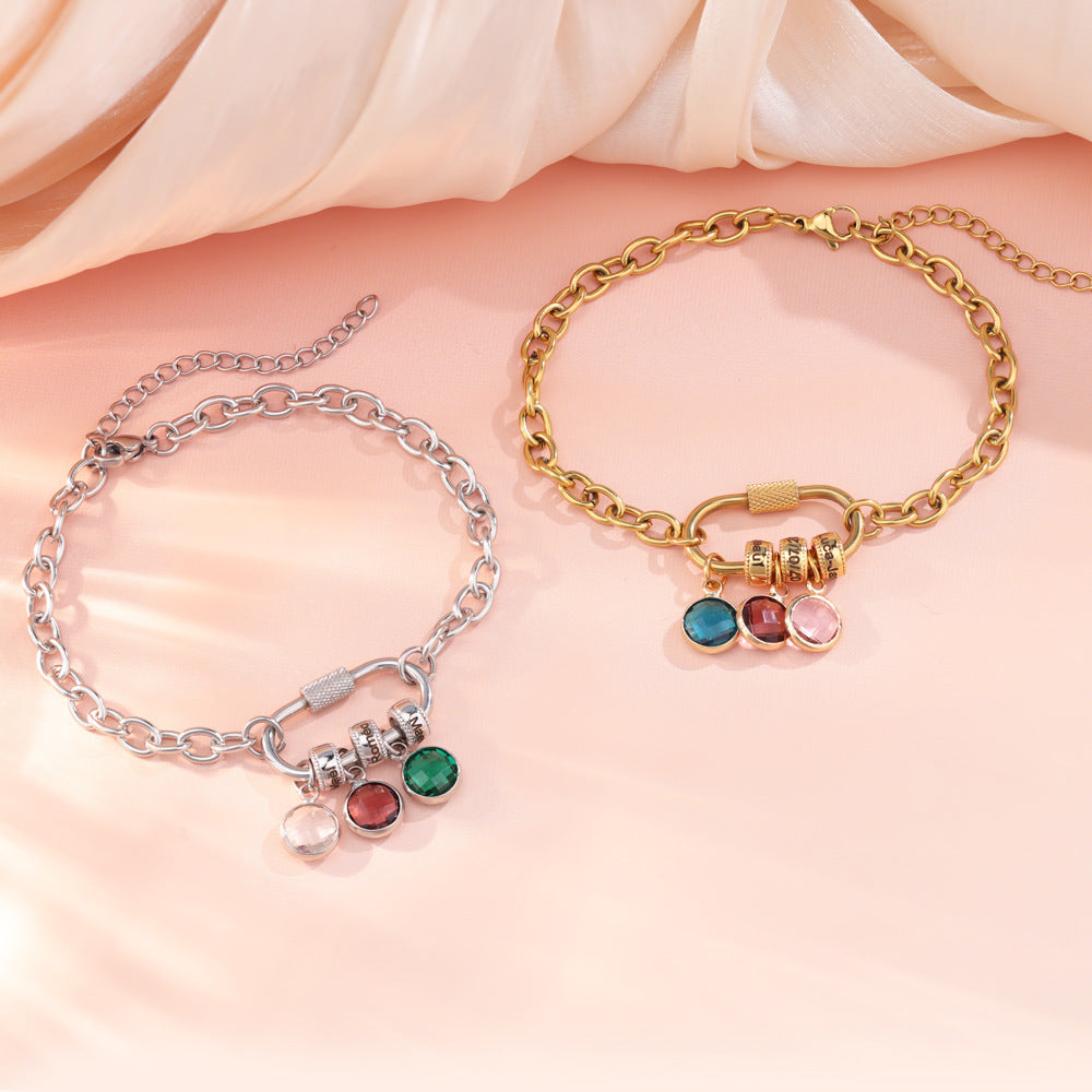 A two-part jewelry set with a pendant and a bracelet, featuring colorful gemstones and metallic clasps, displayed on a surface with pink crystals.