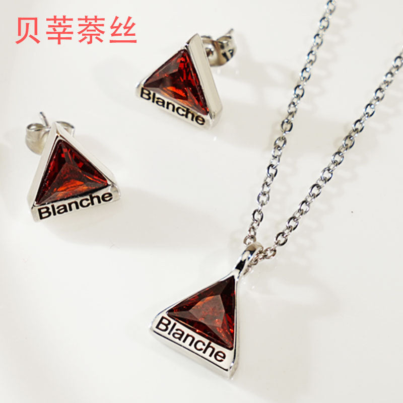 A set of custom engraved stainless steel triangle-shaped necklace pendants with red birthstones, and a matching pair of earrings, all displayed on a chain.