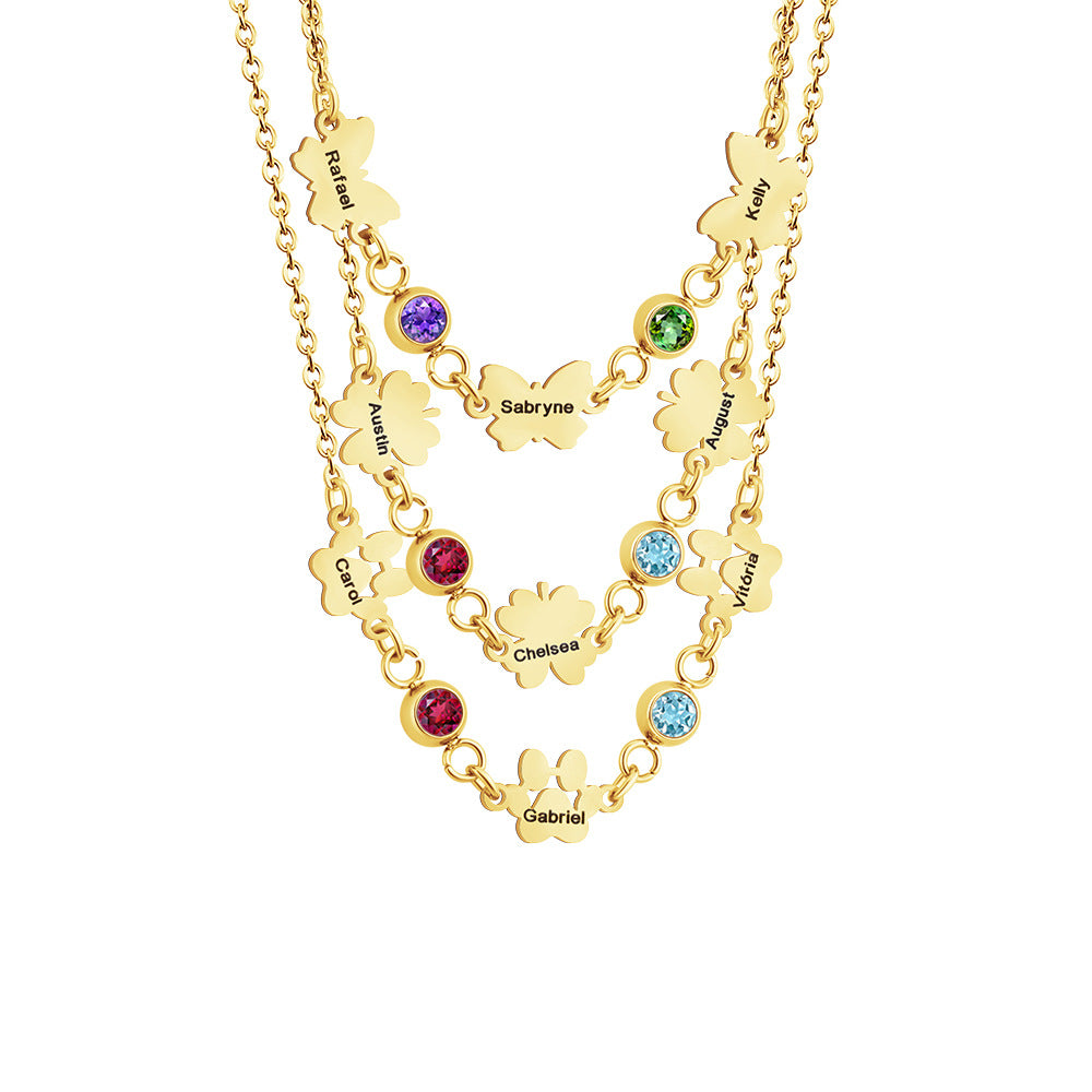 A gold-colored necklace featuring butterfly-shaped pendants with clover-shaped details and vibrant birthstones.