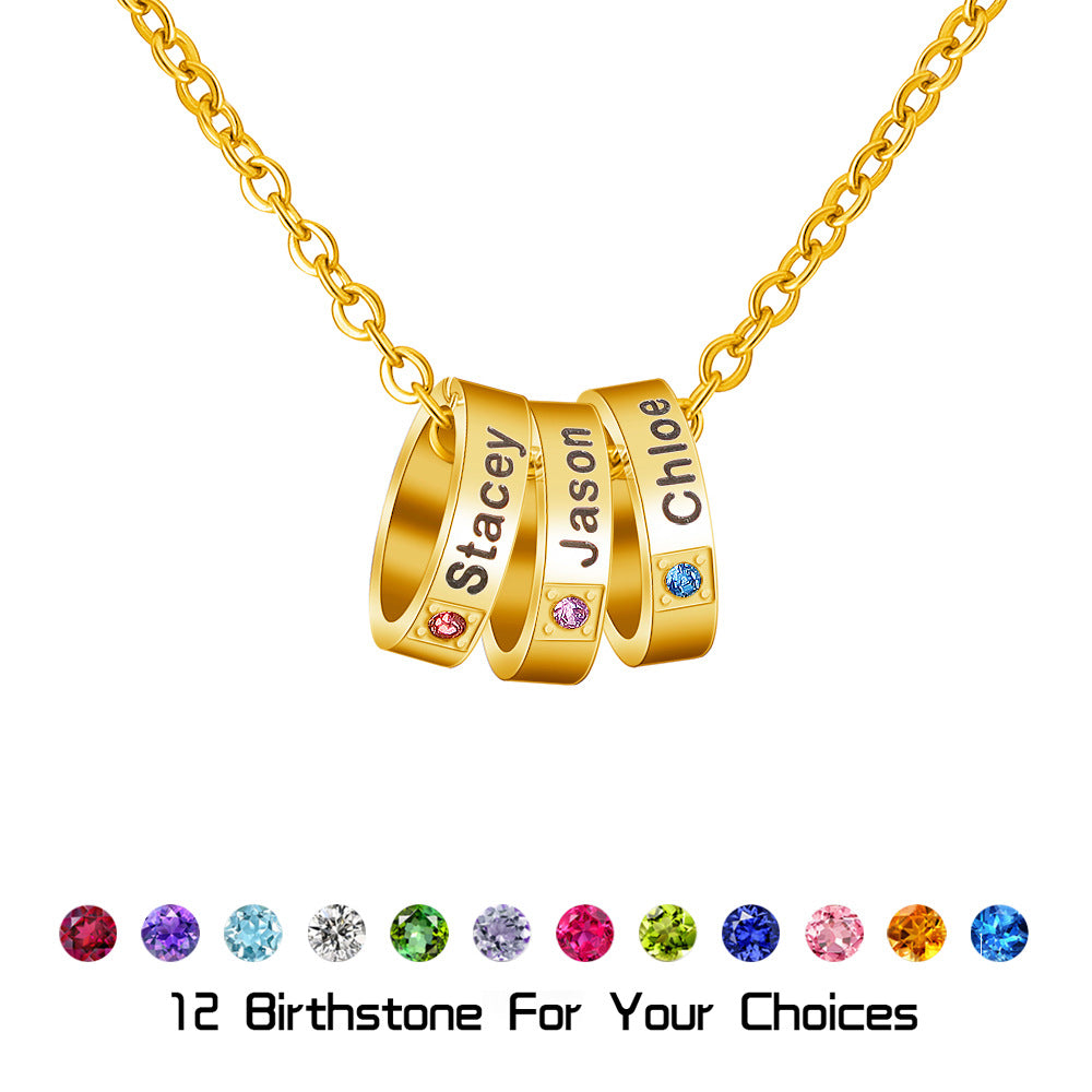 A gold-toned stainless steel necklace with multiple rings featuring various colored birthstones, with the names 'Sarah' and 'John' inscribed on the rings. The necklace is displayed against a white background, and a smaller image shows the necklace in detail, highlighting the birthstones and the ring letters.