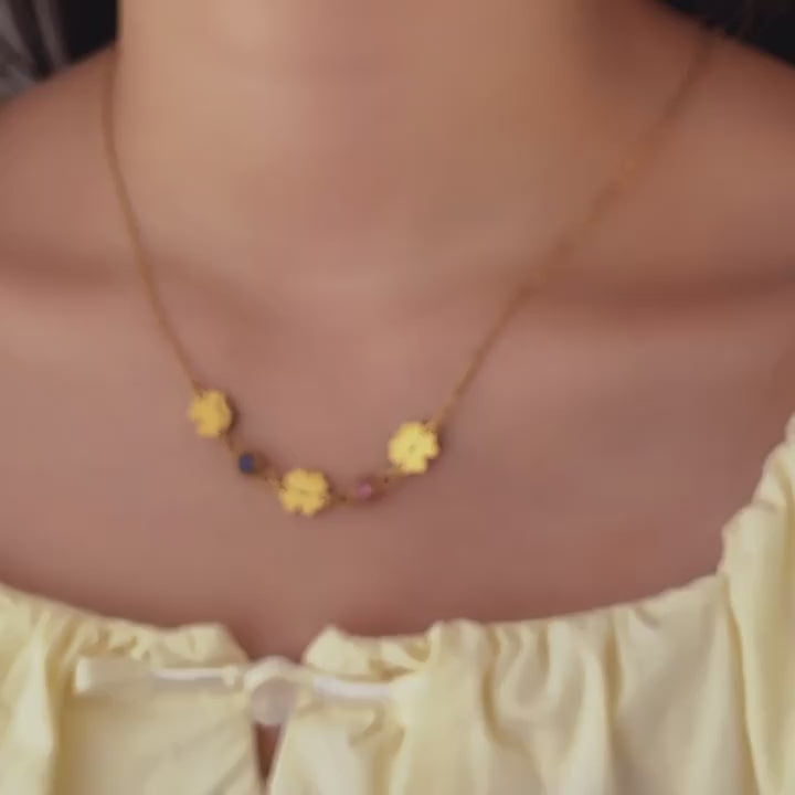 Engraved gold necklace with family names and colorful stones