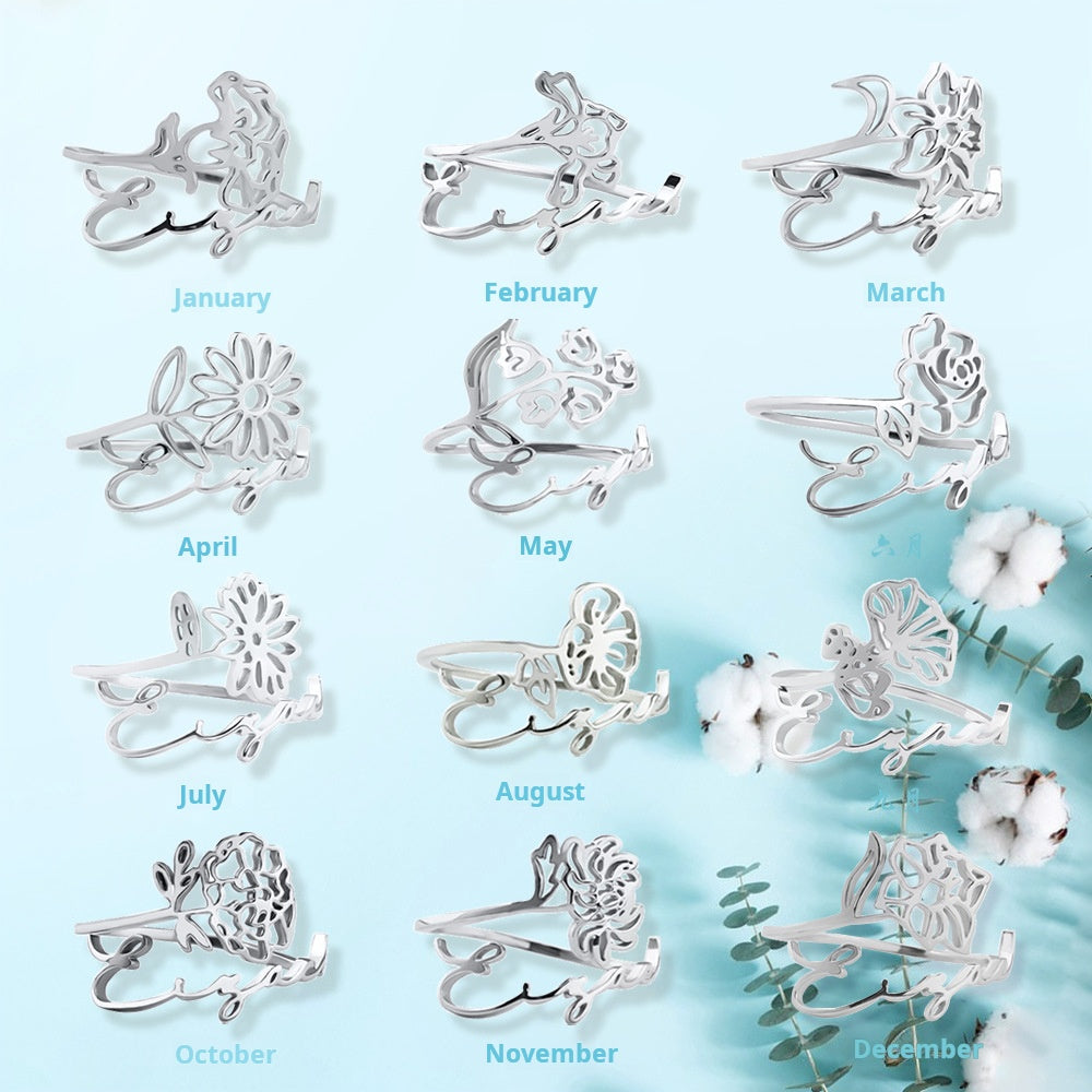 A stainless steel ring with a floral design, placed on a silky fabric surface.